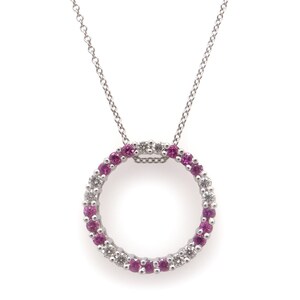 May include: A silver necklace with a circle pendant featuring pink and white gemstones.