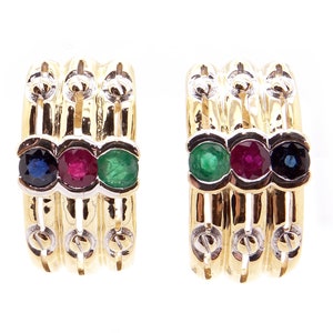 May include: A pair of gold hoop earrings with three gemstones each. The gemstones are a blue sapphire, a red ruby, and a green emerald.
