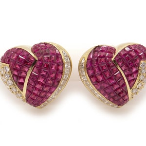 May include: A pair of heart-shaped earrings set in yellow gold, featuring a design of ruby and diamond stones.