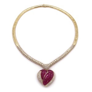 May include: A gold necklace with a heart-shaped pendant set with rubies and diamonds.
