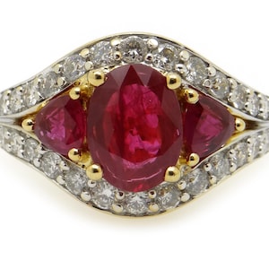 May include: A gold ring with a large oval ruby surrounded by smaller rubies and diamonds.