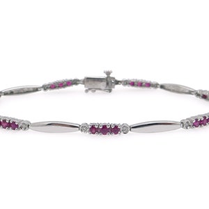 May include: A silver bracelet with a row of pink rubies and small diamonds.