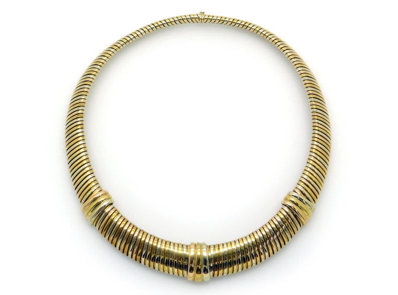 May include: A gold and silver toned necklace with a coiled design.