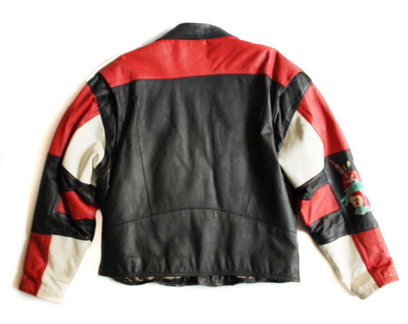 May include: A black leather jacket with red and white panels. The jacket has a zipper closure and a stand-up collar.