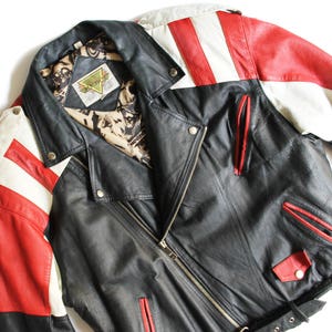 May include: A black leather jacket with red and white striped sleeves. The jacket has a zipper closure and a belt at the waist. The label on the jacket reads "Backlot".
