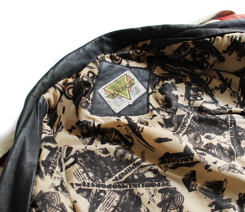 May include: Black leather jacket with a white and black patterned lining. The lining features a small black label with the text "Picket" in white.