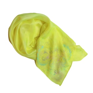 May include: A bright yellow silk scarf with a floral pattern in shades of green, pink, and blue.