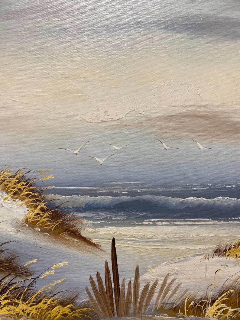Op de afbeelding: Een schilderij van een zeezicht met een zandstrand, blauw water en een paar witte vogels die in de lucht vliegen. Het schilderij is gemaakt in een realistische stijl met zichtbare penseelstreken.
