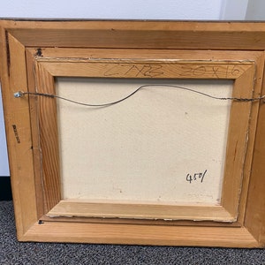 Op de afbeelding: Een houten lijst met een doek erin. Het doek is leeg en heeft een handgeschreven inscriptie op de achterkant die luidt "20x16 450/"