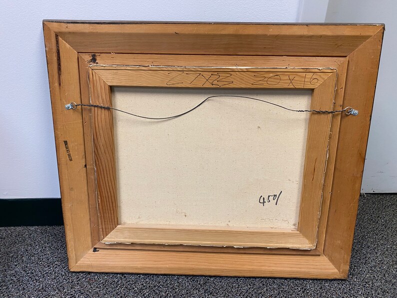 Op de afbeelding: Een houten lijst met een doek erin. Het doek is leeg en heeft een handgeschreven inscriptie op de achterkant die luidt "20x16 450/"