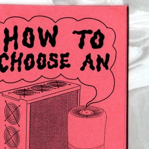 May include: A pink pamphlet with the title "HOW TO CHOOSE AN AIR PURIFIER" in black bold text. The pamphlet features a cartoon illustration of a large air purifier with multiple fans and a smaller, round air purifier.