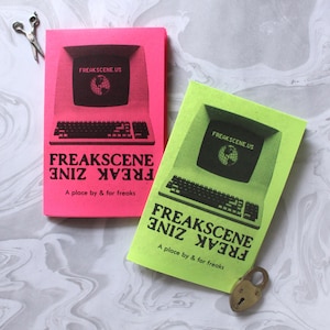 May include: Two rectangular zines, one neon pink and one neon yellow, each featuring a black graphic of a vintage computer monitor displaying the text FREAKSCENE.US and a globe icon. Below the monitor, the text reads FREAKSCENE ZINE A place by & for freaks.