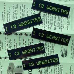 May include: Four black and green stickers with the text "I <3 WEBSITES" in a pixelated font. The stickers are on a green background with text about DIY spaces and resources.