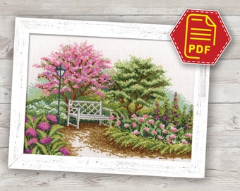 Puede incluir: Patrón de punto de cruz de una escena de jardín con un banco blanco, flores rosas y una farola. El patrón está enmarcado en un marco blanco.