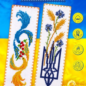 May include: Two cross-stitch bookmark designs featuring Ukrainian symbols. The first bookmark shows a yellow bird with a blue tail holding red berries. The second bookmark shows a blue trident with wheat and blue flowers. Both bookmarks have a white background and orange borders.