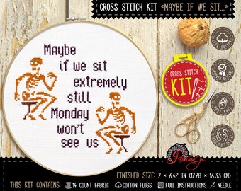 May include: Cross stitch kit featuring two skeletons sitting on chairs with the text "Maybe if we sit extremely still Monday won't see us". The kit includes 14 count fabric, cotton floss, full instructions, and a needle. The finished size is 7 x 6.42 inches.