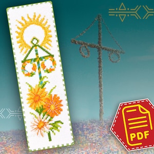 May include: A cross-stitch pattern for a bookmark featuring a yellow sun, a green maypole with yellow and blue decorations, and orange and yellow flowers. The pattern is on white fabric with green borders.