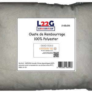 Op de afbeelding: Een witte zak gevuld met 2 kilogram 100% polyester vulling. De zak heeft een label met de tekst "Ouate de Rembourrage 100% Polyester" en draagt het Oeko-Tex Standard 100 logo. Het label bevat ook de tekst "ELANA - 100%PES recyclé, fibres discontinues (100% polyester post-consommation issu de bouteilles PET), blanc et noir."