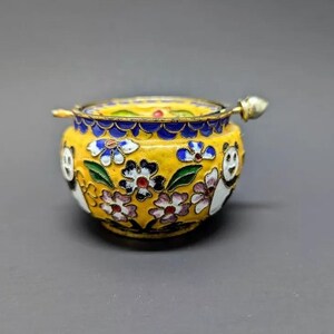 Pu&ograve; includere: Un piccolo vaso in smalto cloisonn&eacute; giallo con un coperchio e un motivo floreale. Il vaso &egrave; decorato con orsi panda bianchi e neri e fiori colorati.