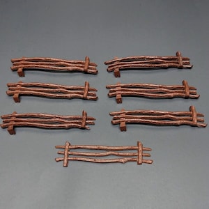 May include: Set of eight brown wooden fence sections, each with four horizontal rails. The sections are approximately 3 inches long.