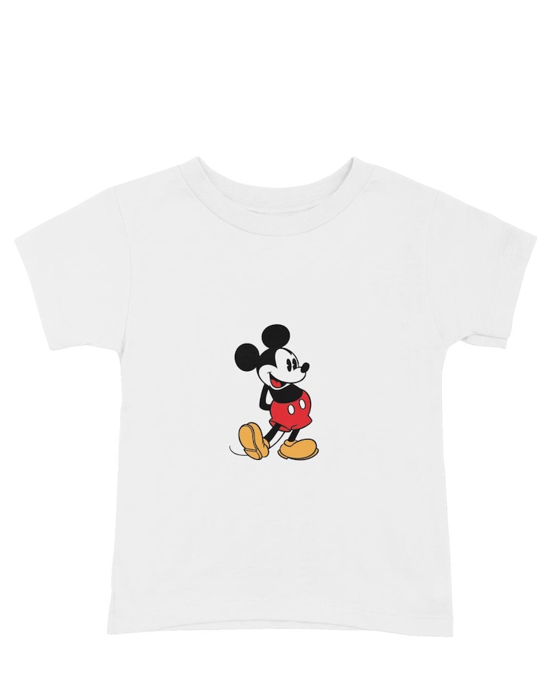May include: White t-shirt featuring a classic cartoon image of Mickey Mouse. The iconic character is depicted in his signature red shorts, yellow shoes, and black gloves. The shirt is a short-sleeved crew neck.