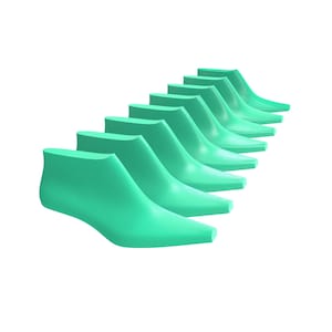 May include: A series of eight identical mint green shoe lasts arranged in a diagonal row. Each form features a smooth, pointed toe and a raised heel section, designed to maintain the shape of footwear during the manufacturing process.