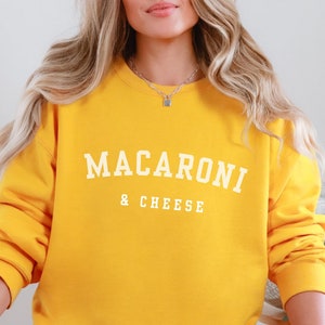 May include: A yellow sweatshirt with the text "MACARONI & CHEESE" in white.