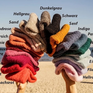 Puede incluir: Una colecci&oacute;n de ovillos de lana en varios colores, incluyendo arena, rosa arena, melocot&oacute;n, casta&ntilde;o, burdeos, magenta, rojo, salm&oacute;n, gris claro, gris oscuro, negro, mostaza, &iacute;ndigo, petr&oacute;leo, verde bosque, menta, azul claro, lila y rosa.