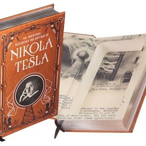 Puede incluir: Un libro encuadernado en cuero marrón titulado "The Inventions, Researches and Writings of Nikola Tesla" con un retrato de Nikola Tesla en la portada. El libro está abierto para revelar un compartimento oculto.
