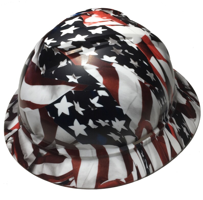 Puede incluir: Un casco de obra con un dise&ntilde;o de bandera estadounidense. El casco es blanco con rayas rojas y azules y estrellas blancas.