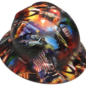 May include: A hard hat with a colorful graphic design featuring American flags, historical figures, and the word "TRUMP". The design includes images of a car, explosions, and a patriotic theme.