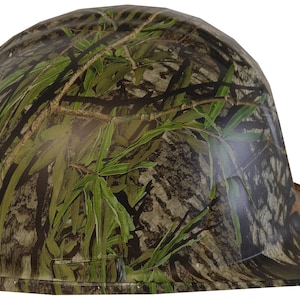 May include: A camouflage hard hat with a flat brim. The hat is green, brown, and black with a leafy pattern.