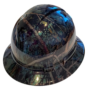 May include: A black, green, and blue camouflage hard hat with the text "Muddy Girl Serenity" printed on the side.