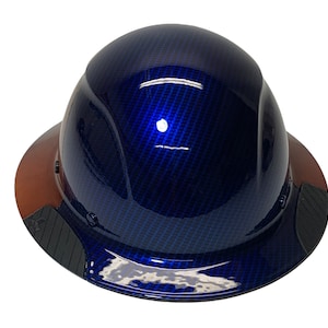 May include: A blue hard hat with a carbon fiber pattern and a brown leather brim. The hat has a black suspension system and a black chin strap.