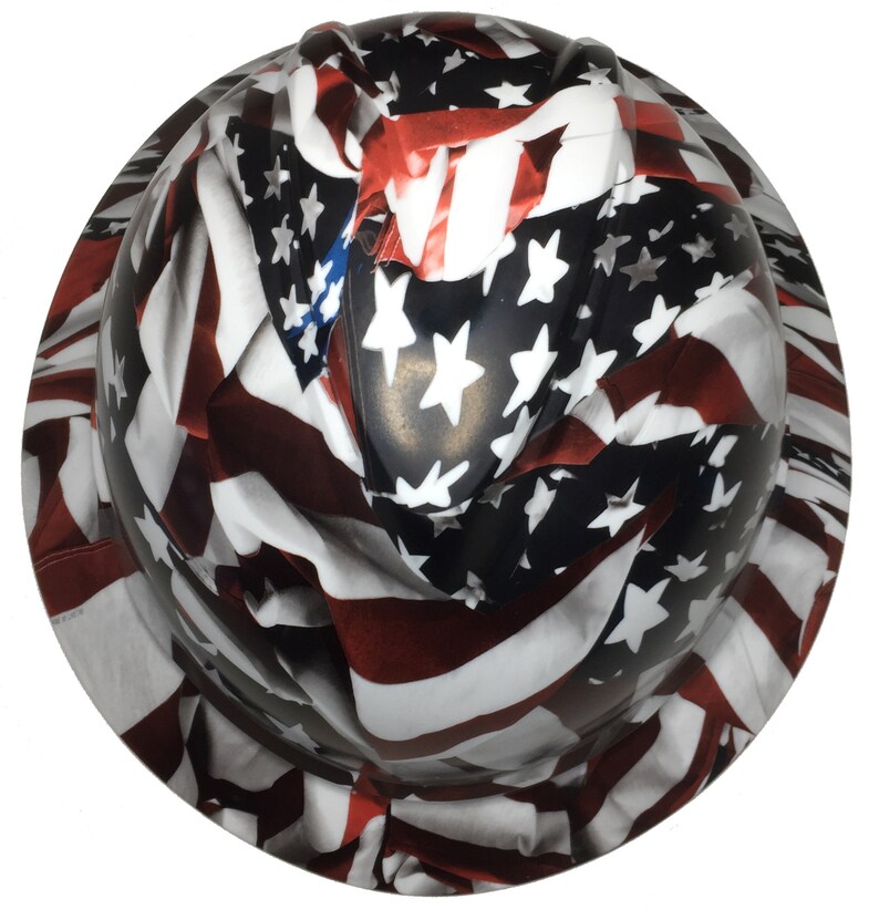 Puede incluir: Un casco de seguridad con un dise&ntilde;o de bandera estadounidense. La bandera est&aacute; impresa en rojo, blanco y azul con estrellas y rayas.