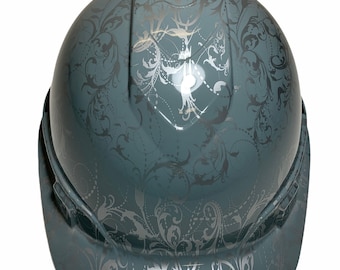 Può includere: Un casco grigio con un motivo floreale argentato.
