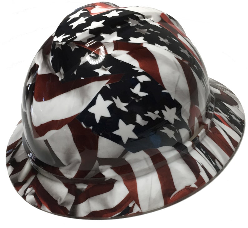 Puede incluir: Un casco de seguridad con un dise&ntilde;o de bandera estadounidense. El casco es blanco con rayas rojas y azules y estrellas blancas.