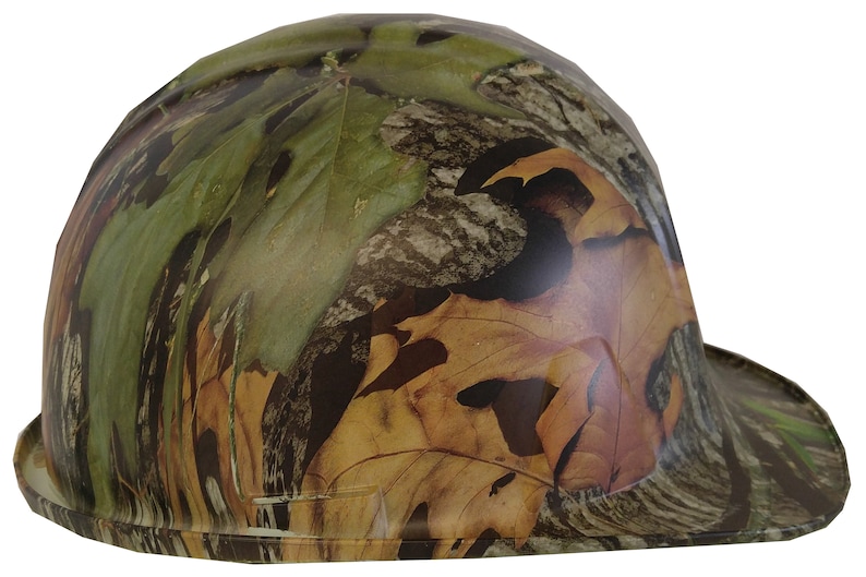 May include: A camouflage hard hat with a wide brim. The hat is made of a durable plastic and features a leafy camouflage pattern in shades of green, brown, and tan.