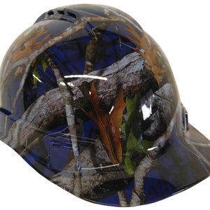 Könnte beinhalten: Ein blauer Helm mit Tarnmuster. Das Muster zeigt braune Äste, Blätter und Rinde auf blauem Hintergrund.