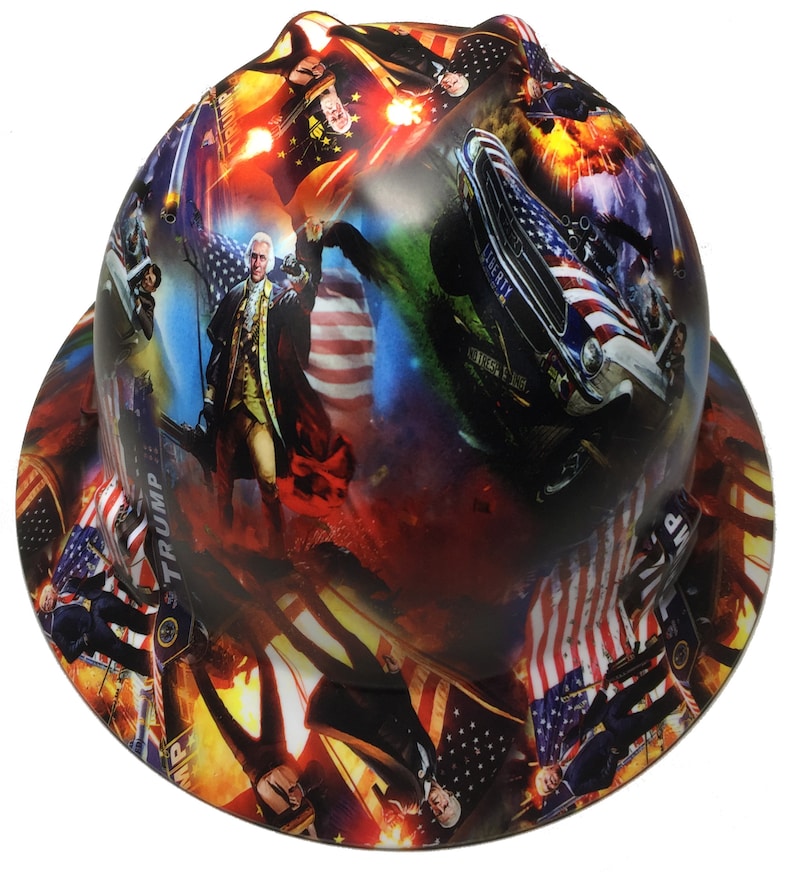 May include: A hard hat with a patriotic design featuring the American flag, historical figures, and a vintage car. The hat has a wrap-around print with a mix of red, white, blue, and other colors.
