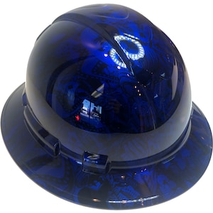 Könnte beinhalten: Ein blauer Helm mit einem schwarzen und weißen abstrakten Design. Der Helm hat einen Rand und ein Aufhängungssystem.