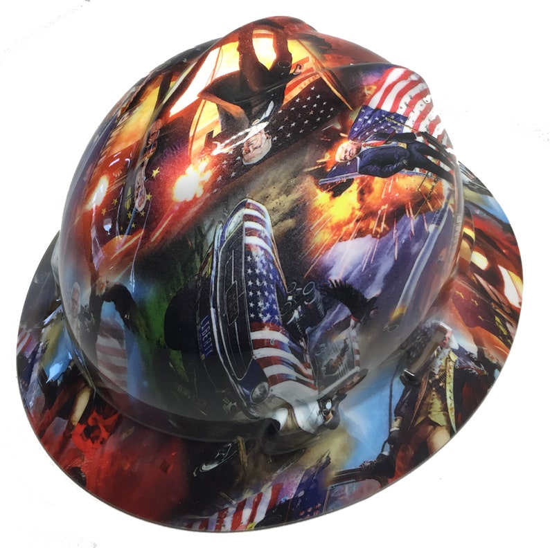 May include: A hard hat with a patriotic design featuring the American flag, historical figures, and military imagery. The hat's surface is covered in a vibrant, multi-colored print, showcasing various scenes and elements.