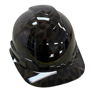 May include: A black hard hat with a camouflage pattern. The hat has a glossy finish and a wide brim.