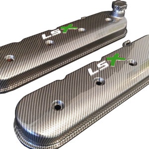 May include: A pair of black and silver engine valve covers with a carbon fiber pattern and "LSX" printed in white with a green "X".