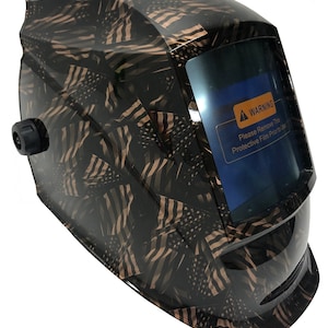 May include: A black welding helmet with a gold and black American flag pattern. The helmet has a clear viewing window with a warning label that reads "Please Remove This Protective Film Prior to Use".