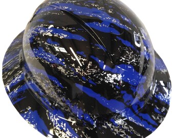 Pode incluir: Um capacete de segurança com um padrão de camuflagem azul, preto e prata. O capacete tem uma viseira e é projetado para trabalhadores da construção.