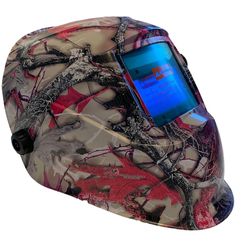 May include: A camouflage welding helmet with a digital display that reads "Warning! Please check the protection level before use."