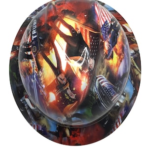 May include: A hard hat with a colorful, digitally printed design. The design features images of people, flags, and the word "TRUMP". The overall color scheme includes red, white, blue, and orange.