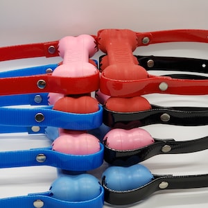 May include: A stack of six dog chew toys, each with a different color. The top two are red with black text that says "Kong". The next two are pink, the next two are blue, and the bottom two are black.