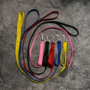 May include: Six colorful dog leashes with silver clips. The leashes are yellow, red, blue, pink, black, and light blue.